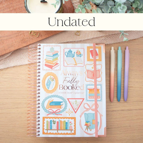 Decorative planner with colorful designs on a wooden surface with pens.